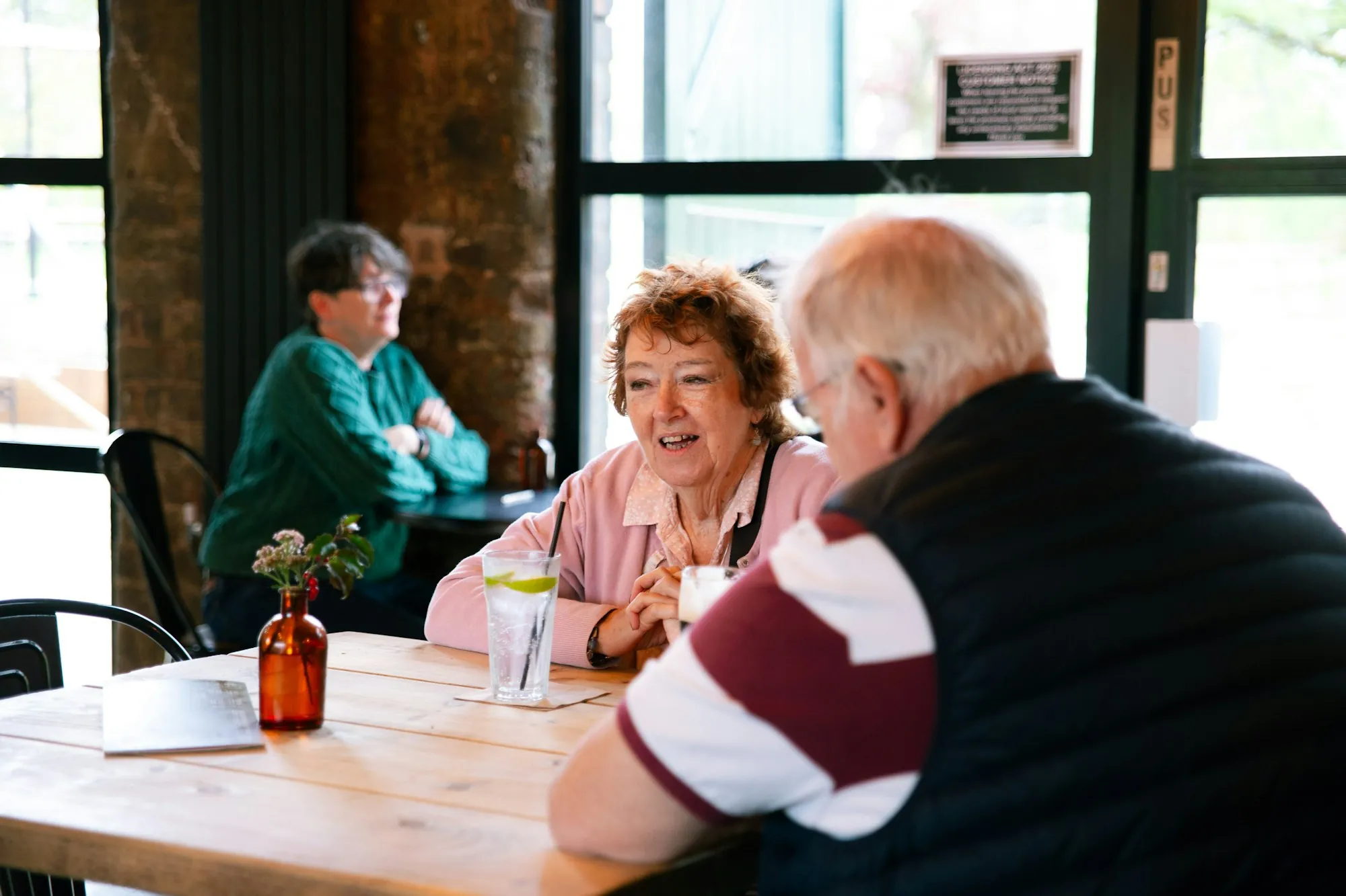 Older friends chatting around a cafe table