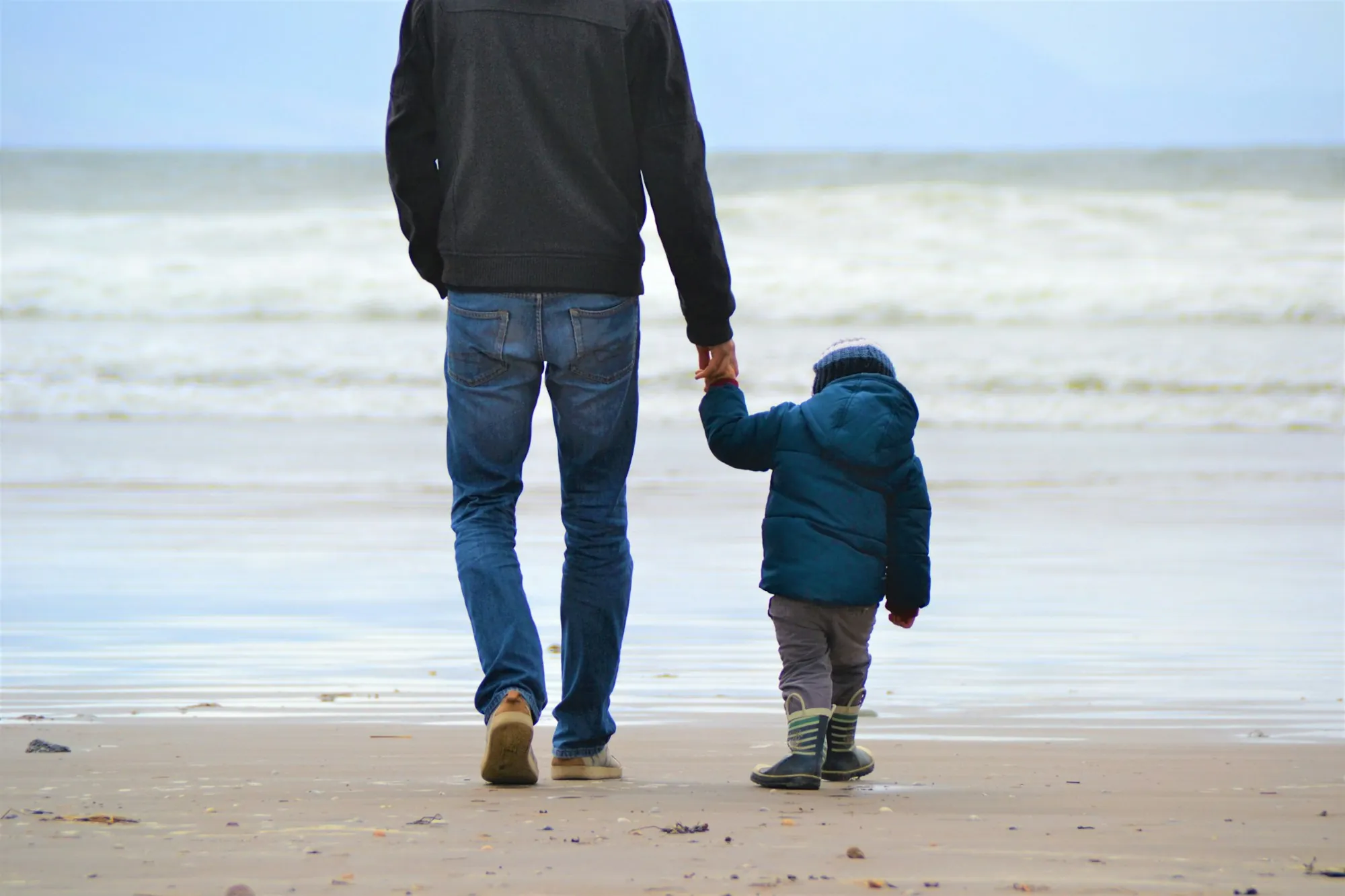 Father and son walking along the beach