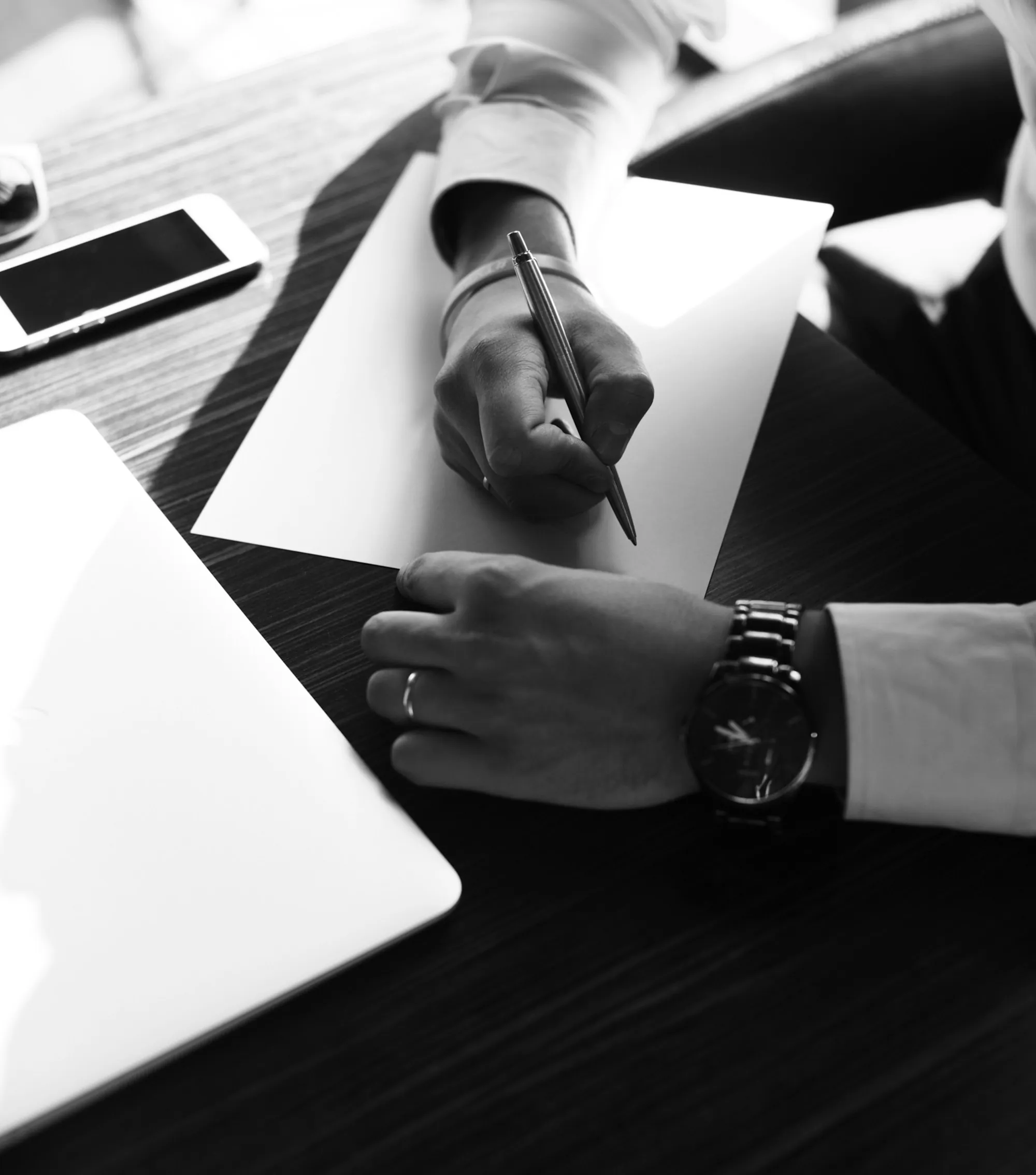 Hand signing papers at a desk while completing a life insurance medical exam application in Arlington Heights